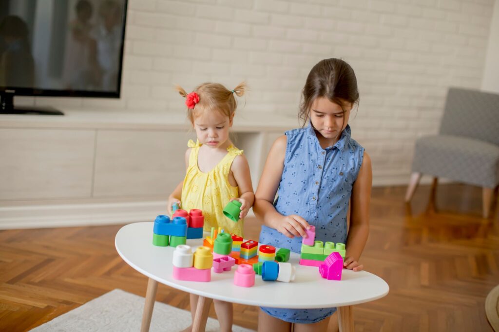 Two little girls play with cubes in the room